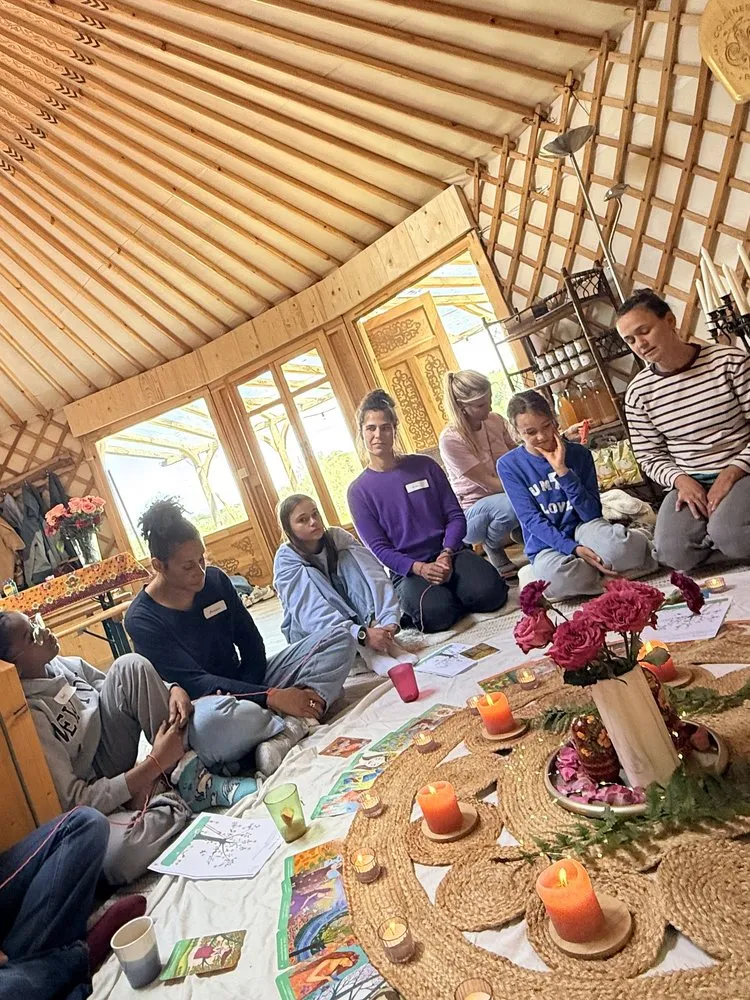 Mamans et jeunes filles assises en cercle autour des bougies, dans la yourte, pendant un Cercle Rose