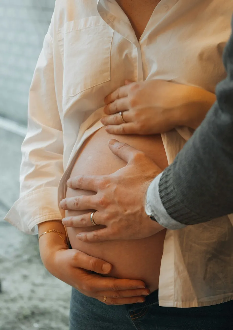 Mains d’un couple posées sur un ventre arrondi