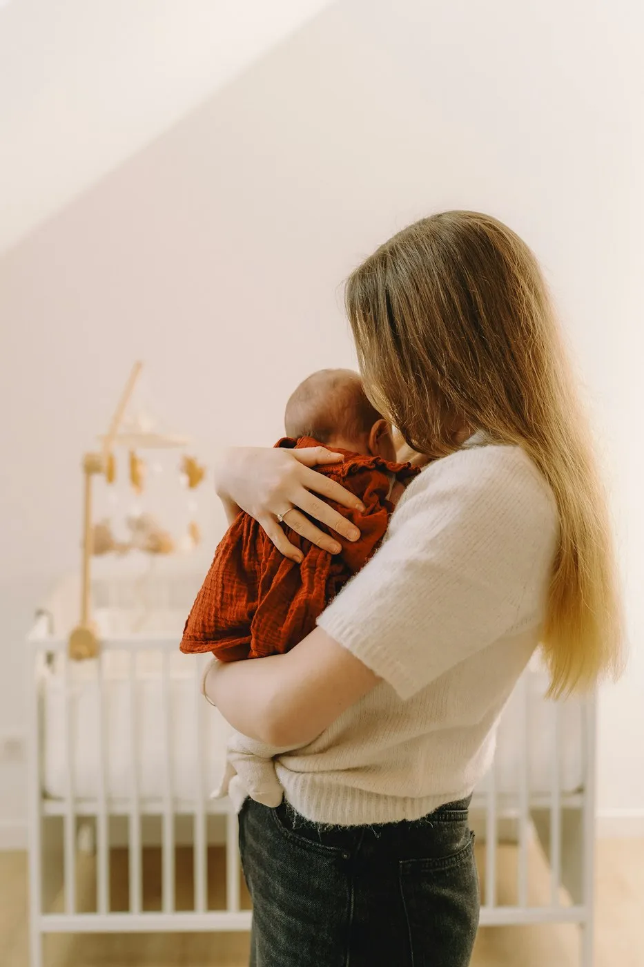 Mère tenant son nouveau-né dans la chambre de bébé