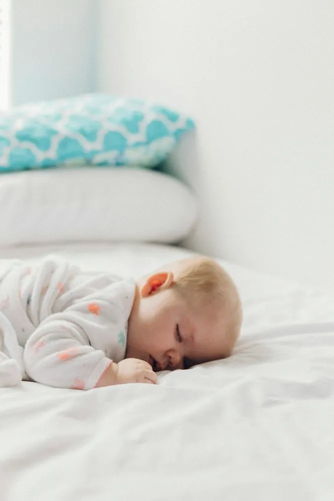 Bébé endormi sur un lit blanc