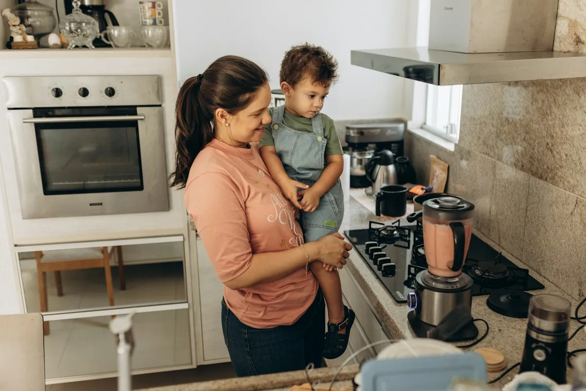 Mère cuisinant avec son enfant dans les bras