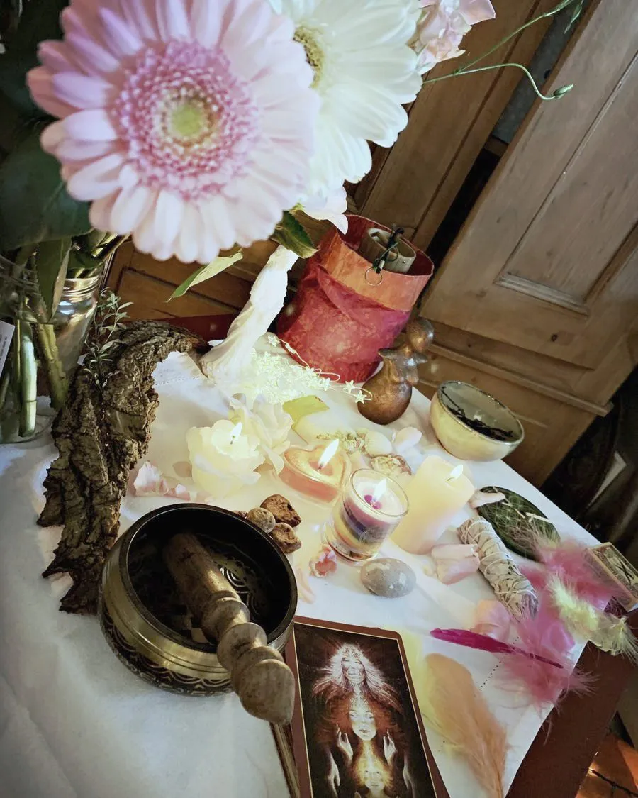 Autel du rituel avec fleurs, bougies, bol chantant et cartes d’oracle